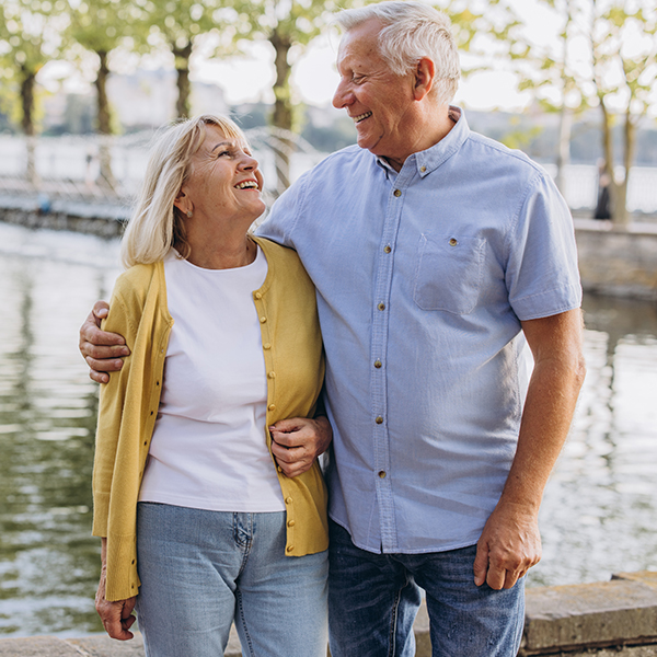 couple smiling by water outdoors what is an iul life insurance faragi group delaware