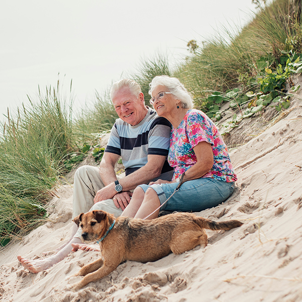 happy senior couple on beach with dog fixed indexed annuity faragi group delaware
