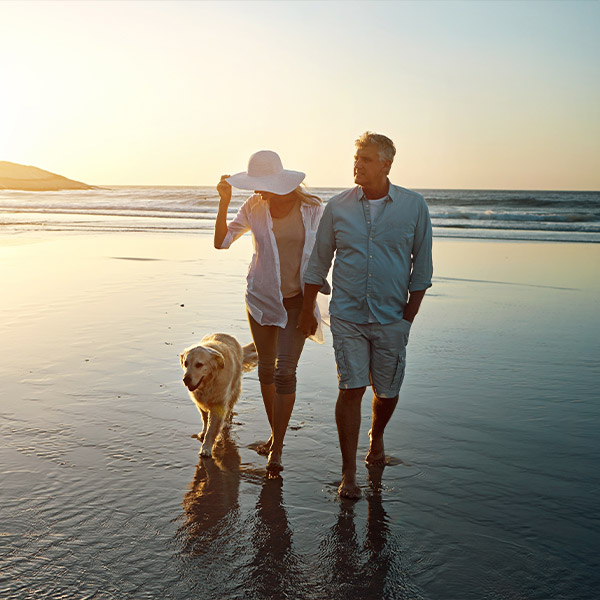 retired couple walking their dog on the beach simple retirement options